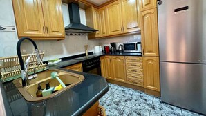 A kitchen with wooden cabinets, a stainless steel refrigerator, a microwave, and a stove.