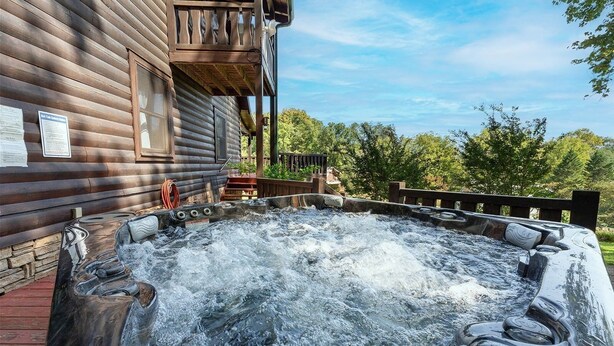 A wooden cabin with a hot tub in front.