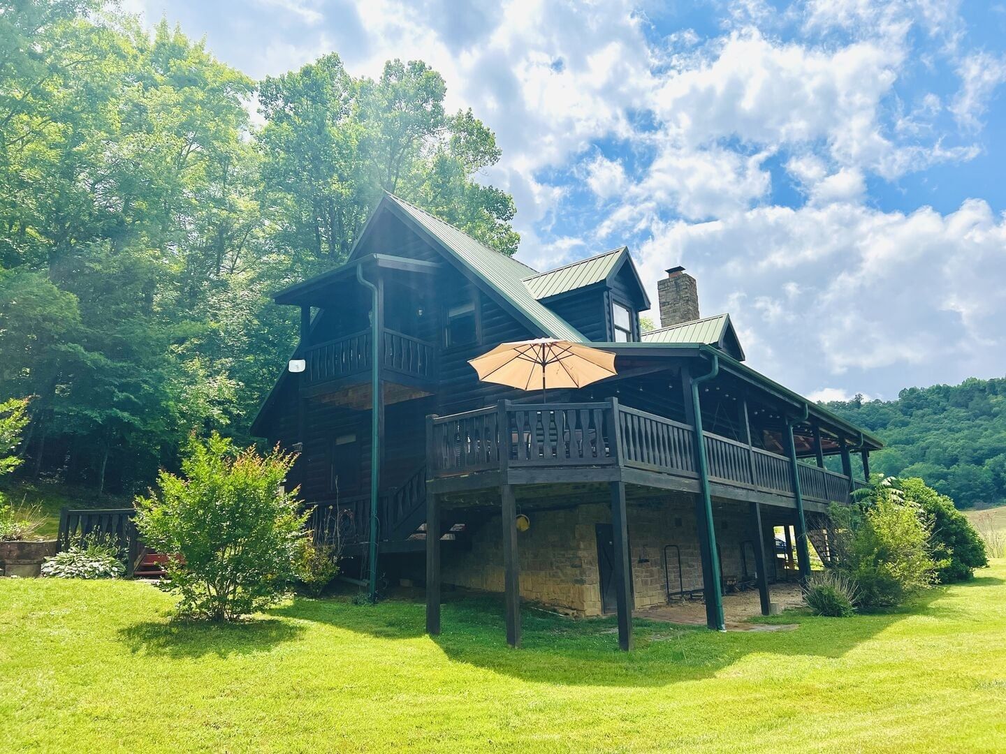 A wooden cabin with a balcony and a covered porch area.