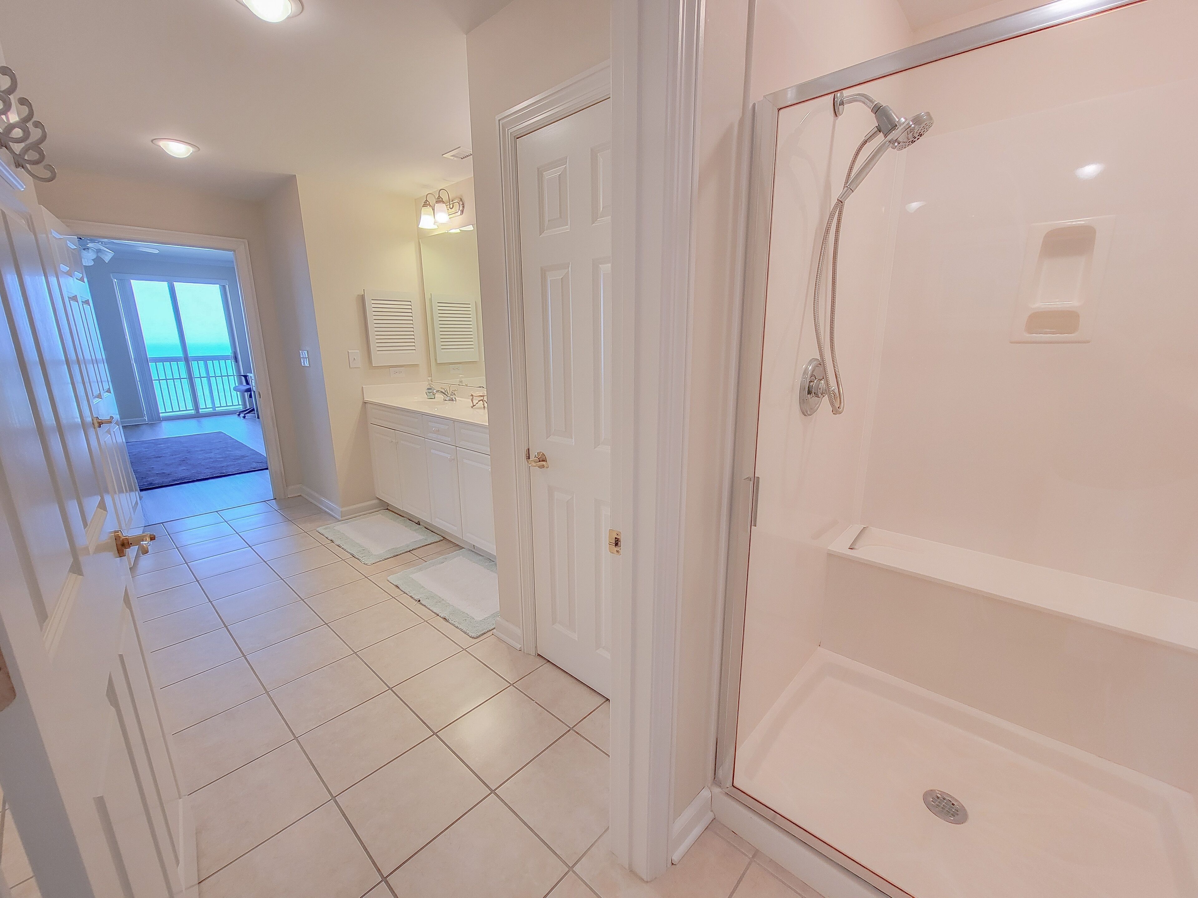 A bathroom with a shower, a sink, and a mirror.