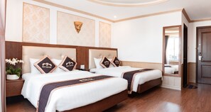 Ein Hotelzimmer mit zwei Betten, einer Topfpflanze und einem Spiegel.