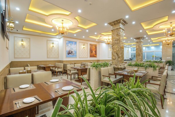 A restaurant with multiple dining tables, chairs, and a variety of wall art.
