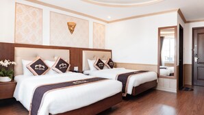 Habitación de hotel con dos camas, cabecera de madera, lámpara de pared y espejo.