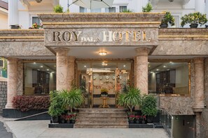 Het uiterlijk van Hotel Roy Dal met marmeren zuilen, een statig entree en potplanten.
