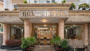 Roy Dalal Hotel set med marmorkolonner, en storslået indgang og plantekasser.