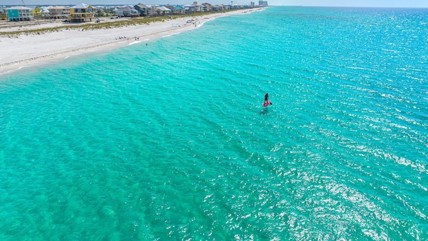 A beach with clear turquoise waters and a person paddleboarding. - Narvana-Gulf View Home Across from Beach. Pup Friendly (Navarre)