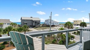A beachfront property with a wooden deck, a chair, and a view of the ocean. - Narvana-Gulf View Home Across from Beach. Pup Friendly (Navarre)