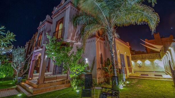 A large, multi-story building with a traditional architectural style, featuring arched windows and a balcony. - Magnifique Villa Azao, Jusqu'à 6 Chambres /pool/jacuzzi (Marrakech)