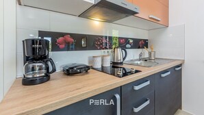 A modern kitchen with a coffee maker, a kettle, and a toaster on the counter.