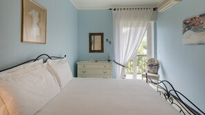 A bedroom with a bed, a dresser, a mirror, and a window with curtains. - Un Balcone Sulle Colline di Rapallo by Wonderful Italy (Rapallo)