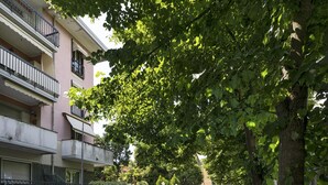 A multi-story residential building with balconies, parked cars, and trees. - Un Balcone Sulle Colline di Rapallo by Wonderful Italy (Rapallo)