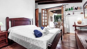 A bedroom with a wooden bed, a nightstand, and a table with a lamp. - Casita Fontxica - Two Bedroom Villa, Sleeps 4 (Mallorca)
