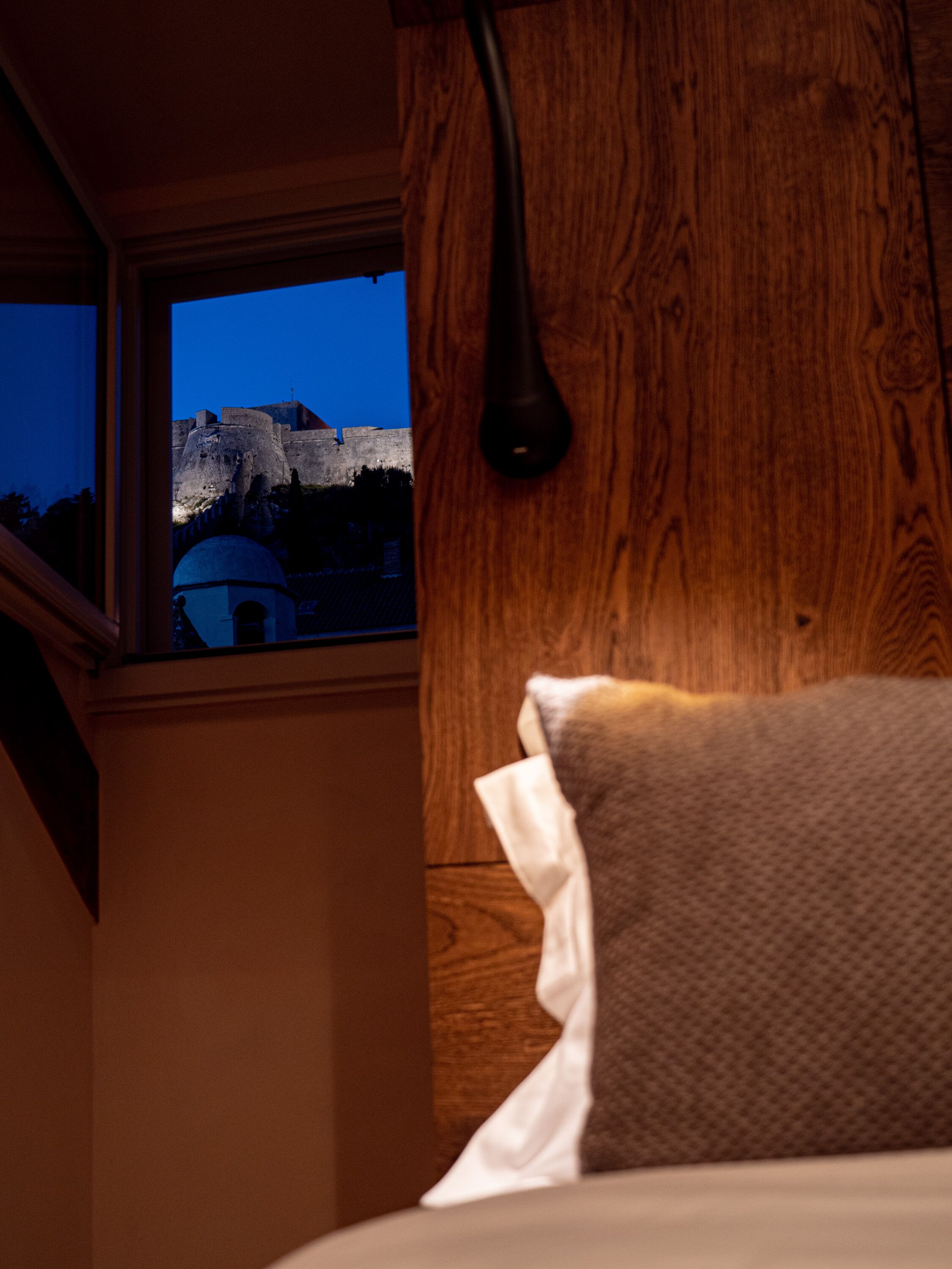 A wooden wall with a window overlooking a historic fort.