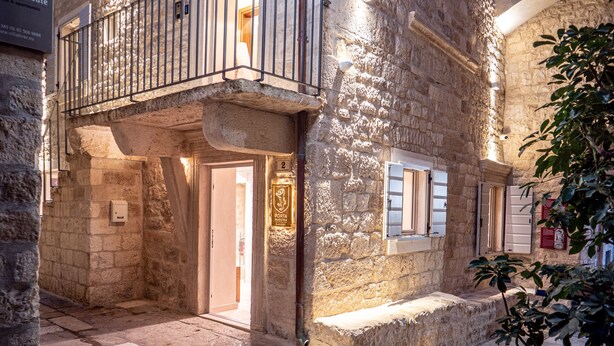 A stone building with a balcony, a door, and a window with shutters. - Villa Porta Maestra (Hvar)