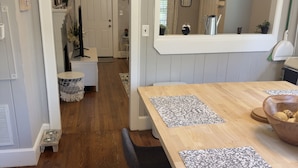 A dining area with a wooden table, two chairs, and a large mirror above the table. - {Sunflower Morning} A cozy farmhouse-style house in South End HOT TUB! (Charlotte)