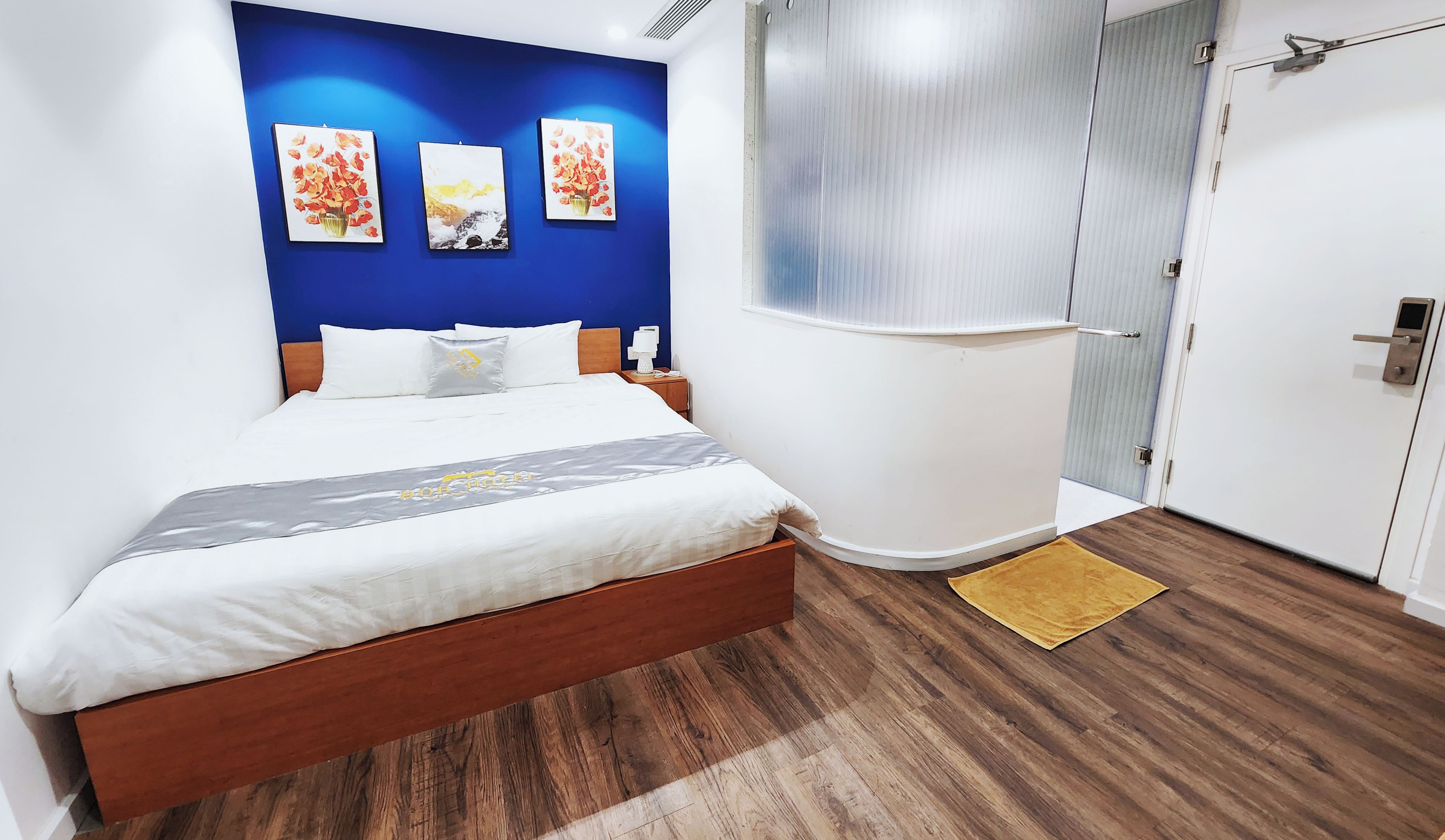 Habitación de hotel con cama, armario y puerta al baño.