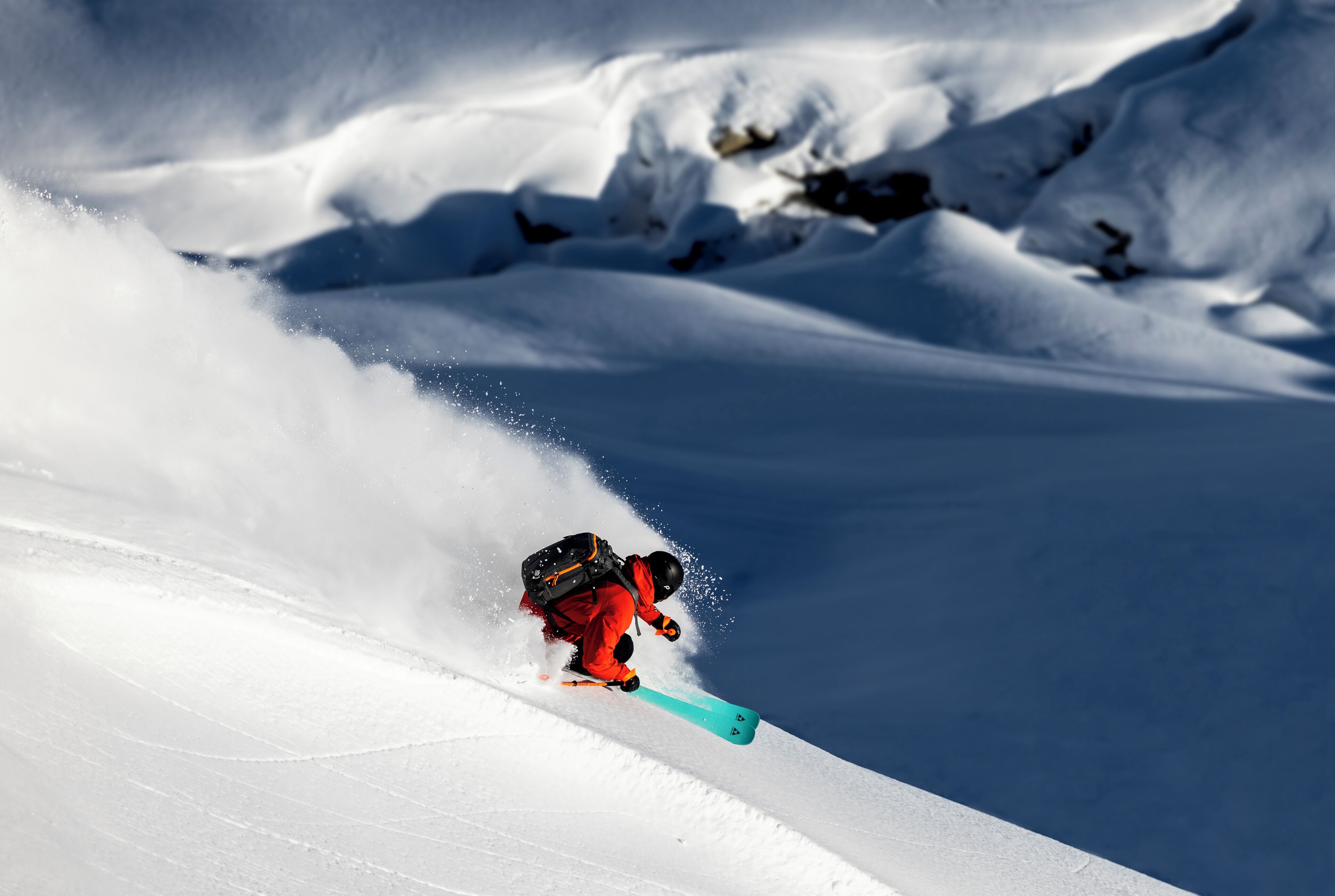 A skier in motion on a snowy slope.