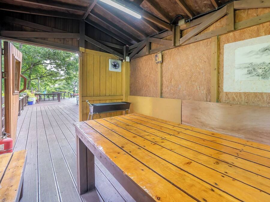 Una terraza de madera con un banco y un cuadro colgado en la pared.