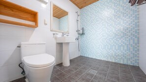 A bathroom with a toilet, sink, and shower.