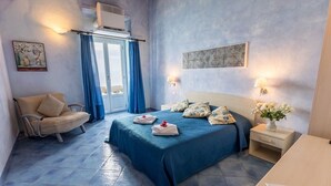 Quarto com cama, cadeira, mesa de cabeceira e ar condicionado fixado na parede.