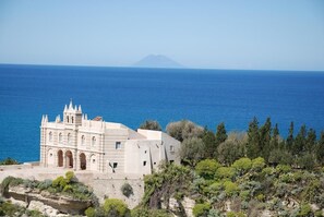 A coastal building with a prominent tower, situated on a cliff overlooking the sea. - Blu Tropea Maison (Tropea)
