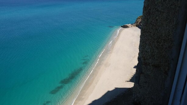 Uma praia com águas turquesa cristalinas e areia dourada.