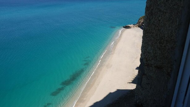 A beach with clear turquoise water and a sandy shore. - Blu Tropea Maison (Tropea)