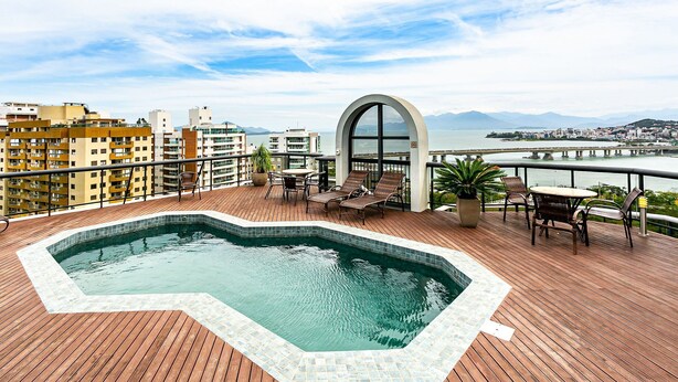 Un espace piscine sur le toit, offrant une vue sur la ville et les montagnes.
