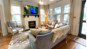 Ein Wohnzimmer mit Kamin, Fernseher und einer Couch.