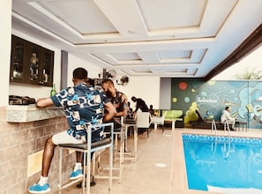 A poolside area with a bar, seating, and a mural. - Boston Hill Resort & Hotel Ltd (Umuoji)