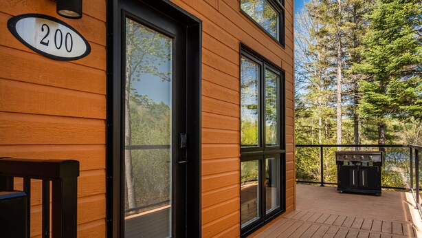 A wooden exterior with large windows and a deck area.