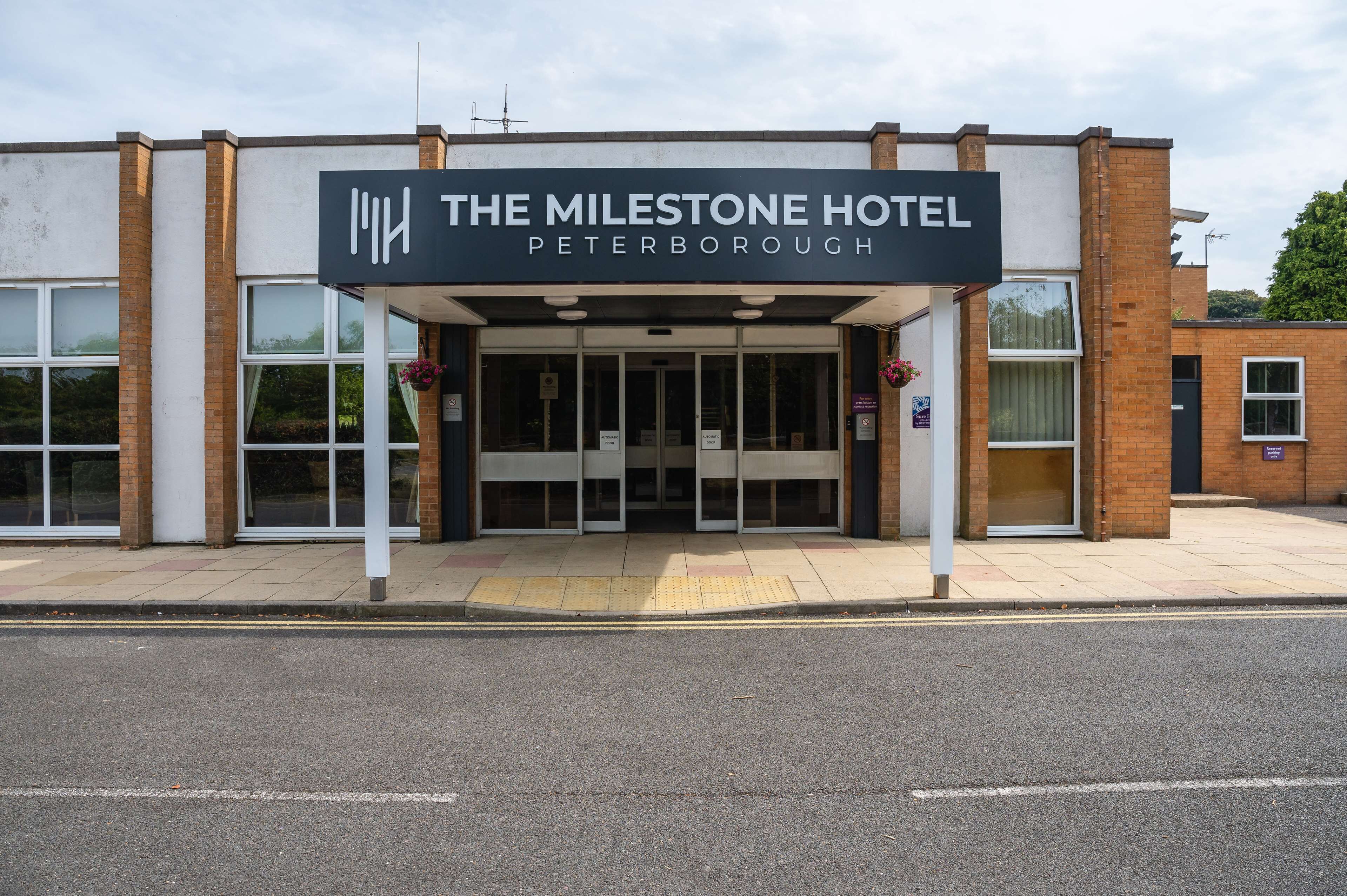 Das Äußere des Milestone Hotel in Peterborough, mit einer modernen Fassade, großen Fenstern und einem markanten Eingang.