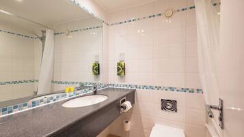 Ein Badezimmer mit Waschbecken, Spiegel, Toilette und Dusche.