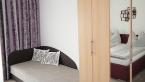 A bedroom with a bed, a wardrobe, and a nightstand. - holiday apartment Elferblick (Fulpmes)