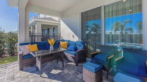 Ein Patio mit einer Sofagruppe, einem Glastisch und Stühlen.