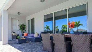 Eine Terrasse im Freien mit Korbmöbeln, einer Couch und einem Tisch.