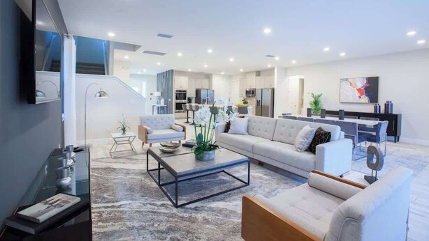 Un salon moderne avec un canapé, une table basse et un téléviseur fixé au mur.