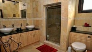 A bathroom with two sinks, a shower, and a toilet. - Maison de La Mer (Castries)