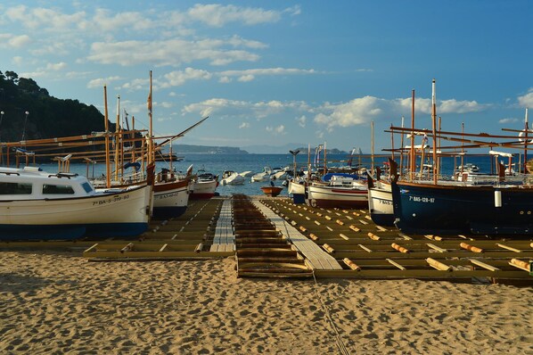A beachside marina with boats docked along wooden piers.