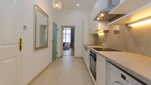 A modern kitchen with a built-in washing machine, a large mirror, and a pendant light. - Vienna Residence, Adamberg - Leopoldstadt #6310 (Vienna)