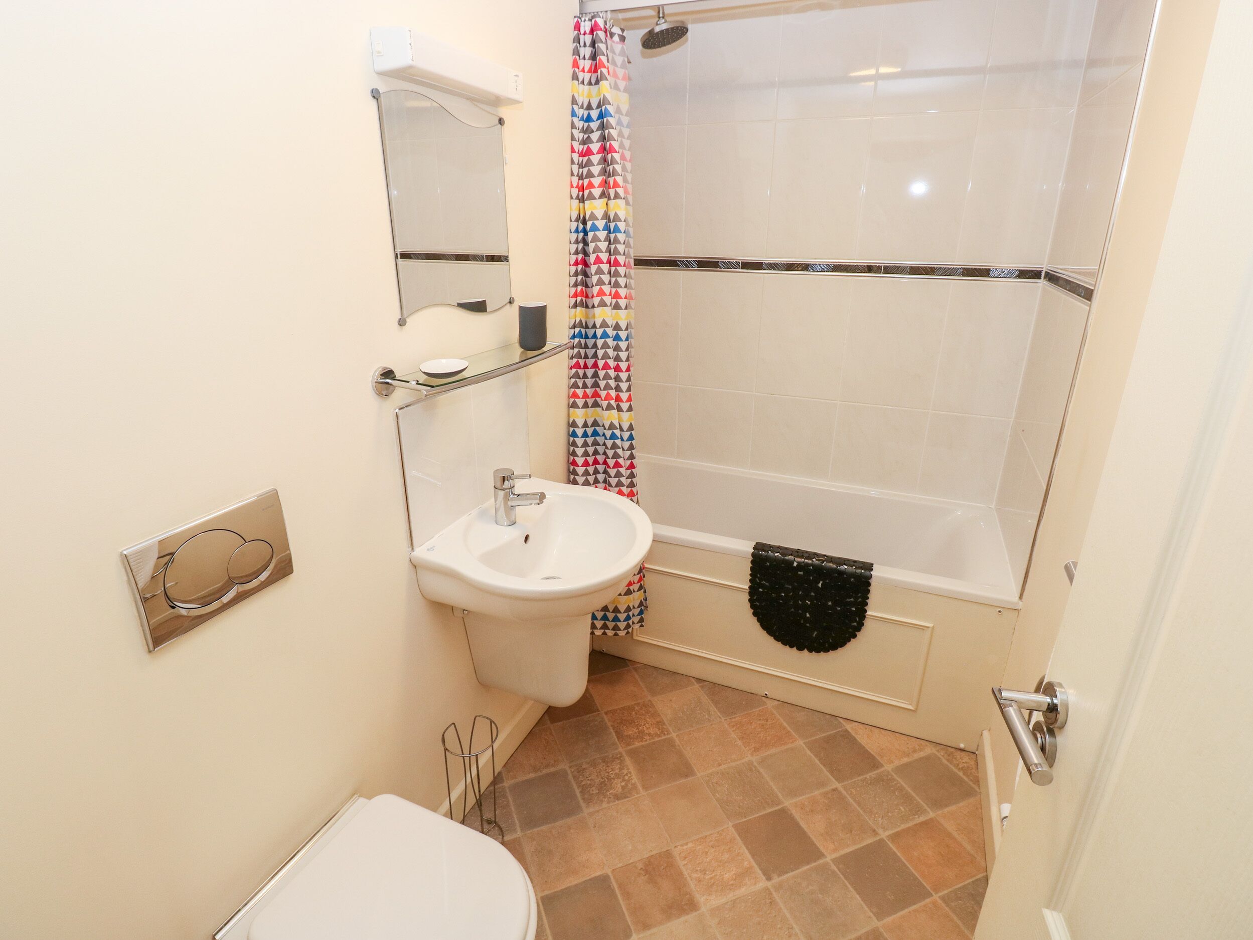 Een badkamer met wastafel, spiegel, toilet en douche.