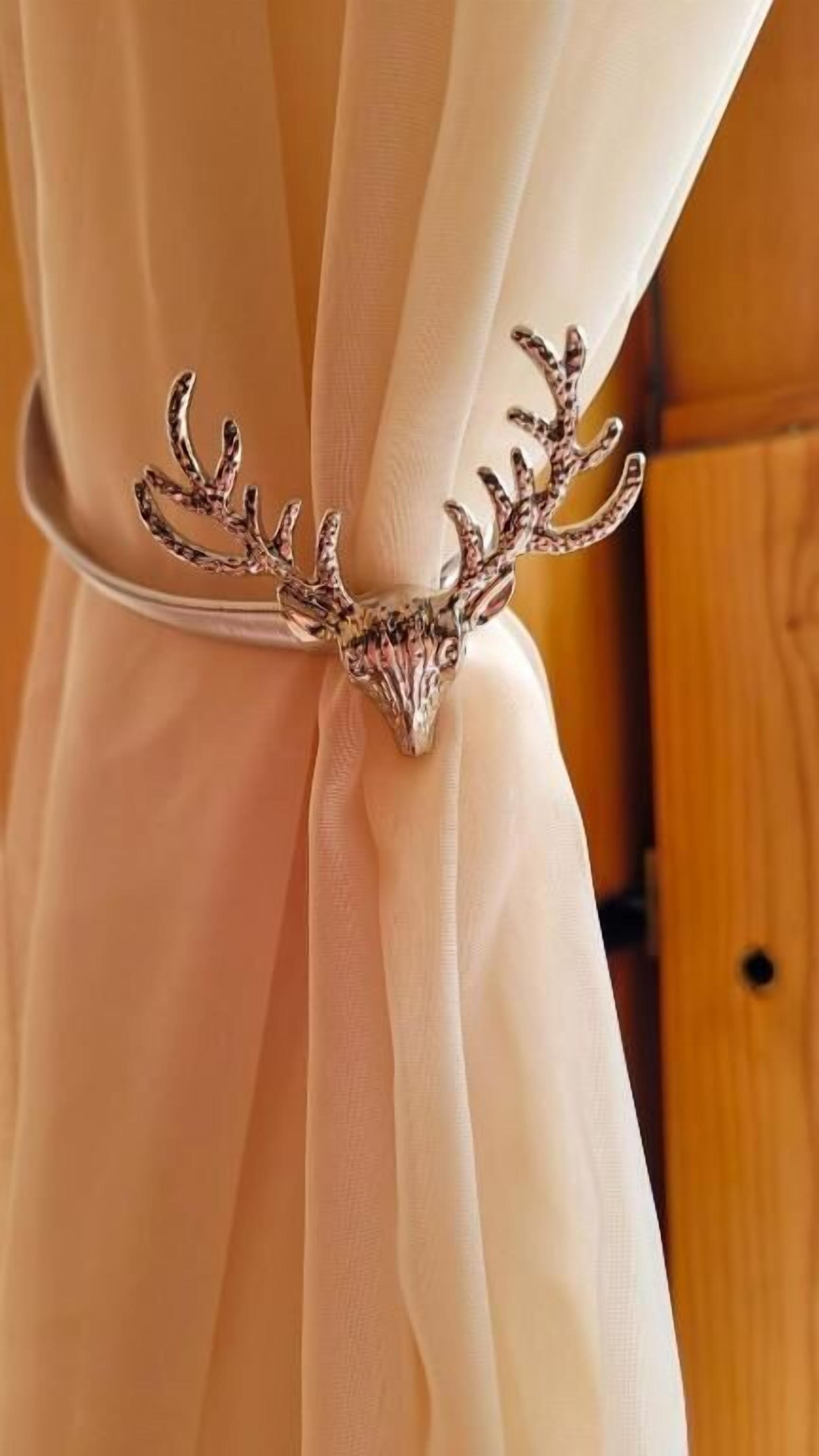 A metallic deer antler headband tied around a white fabric.