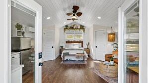 A spacious room with a wooden ceiling, a bed with a white headboard, a dining area with a table and chairs, and a kitchen with modern appliances. - "New Listing" Private Romantic Guest Loft with a VIEW! (Marion)