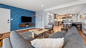 A modern living room with a flat-screen TV, a dining area, and a kitchen. - Steps To Lake|Garage Parking|Fire Table|Deck|Bikes (Minneapolis)