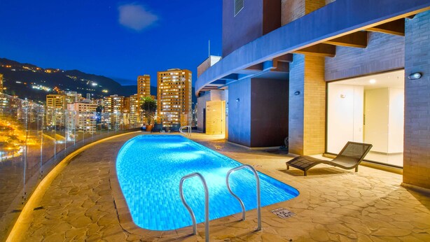 A rooftop pool with a clear view of the city skyline and mountains in the background. - Poblado Paradise for Your Stay 2br 2bath (Medellín)