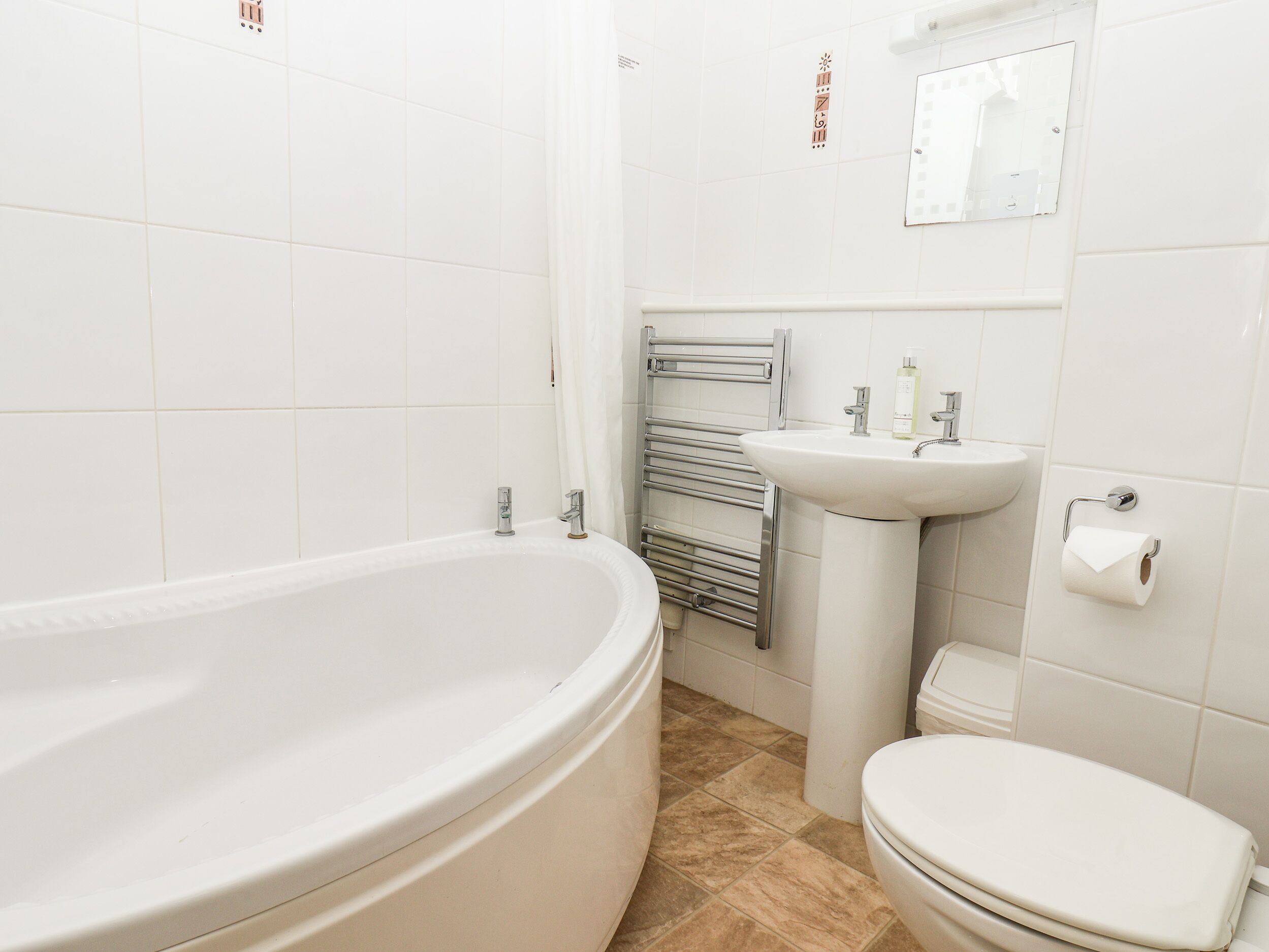 A bathroom with a bathtub, sink, and toilet.