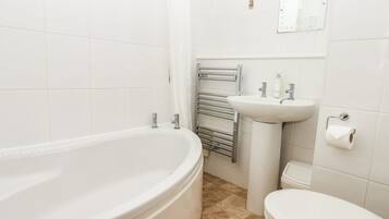 A bathroom with a bathtub, sink, and toilet.