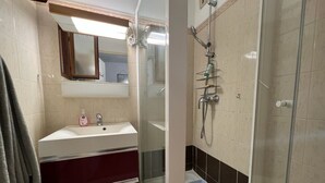 A bathroom with a glass-enclosed shower, a sink with a mirror above it, and a vanity with drawers. - Le tinharé - studio with garden near the sea (La Ciotat)