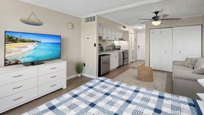 Ein modernes Wohnzimmer mit einem großen Flachbildfernseher, einem karierten Teppich und einem Sofa.