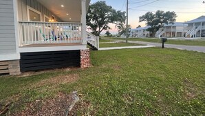 A single-story house with a front porch and a small brick foundation. - BRAND NEW Beach House with Gulf Views! Less than 3 min walk to the beach! (Gulfport)